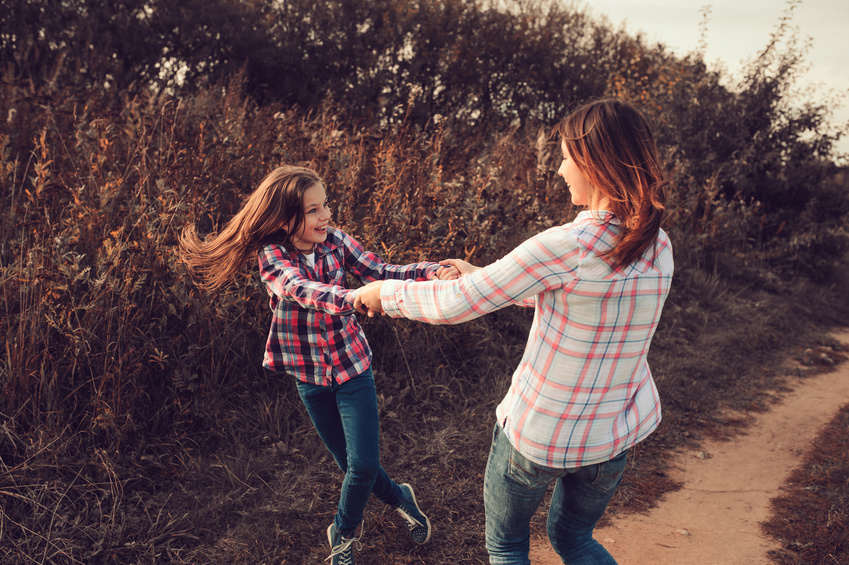 happy mother and daughter on the walk on summer field. Family spending vacation outdoor, lifestyle capture.